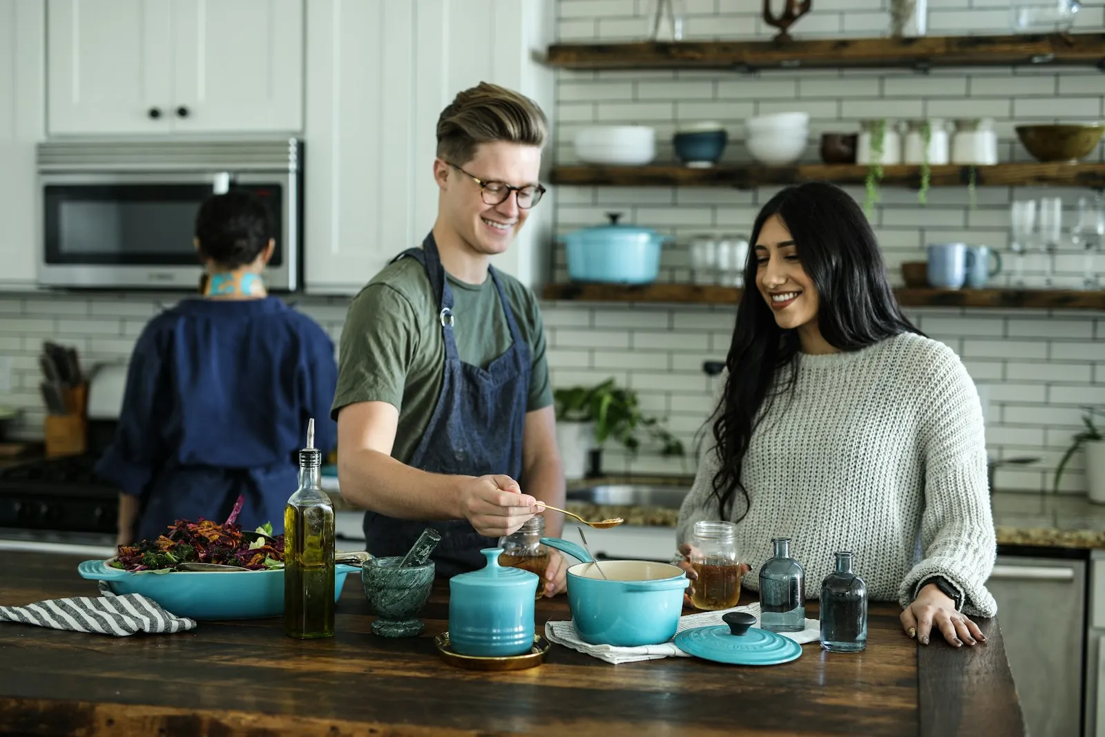 A bright home kitchen with open shelving and colorful cookware